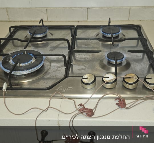 כיריים גז עם להבות כחולות, כלים וציוד עבודה על השיש